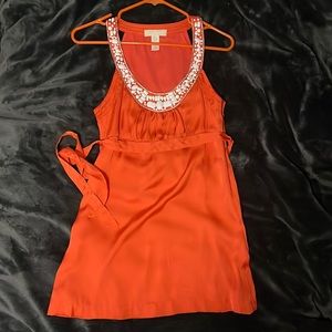 Orange blouse with white and silver accent beading. Size small